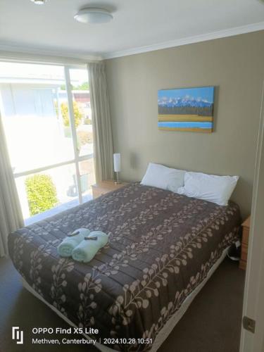 a bedroom with a bed with two towels on it at Opuke Crash Pad Methven - with mountain views. in Methven