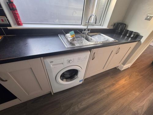 a kitchen with a sink and a washing machine at Central Near Hospital 2 Bedroom - Sleeps 4 - Self Check In - Fully Furnished in Carlisle