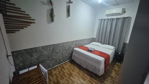 a small bedroom with a bed and a staircase at Pousada Cactos in Chapada dos Guimarães