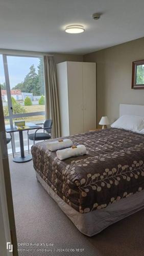 a bedroom with a large bed and a table and a window at Mt Hutt Studio at 23 Methven in Methven