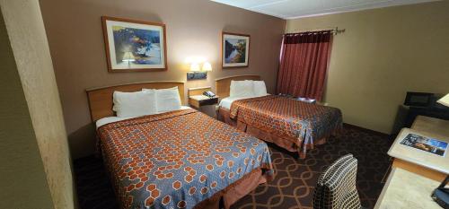 a hotel room with two beds and a window at American Inn Evansville East in Evansville