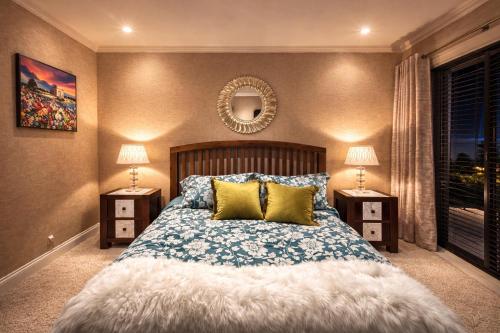 a bedroom with a bed with two lamps and a mirror at Skyline Luxury Penthouse Belfast City Centre in Belfast