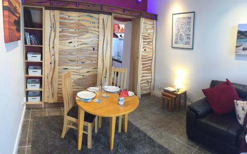 a living room with a wooden table and a couch at Artisan Studio in Tarbert