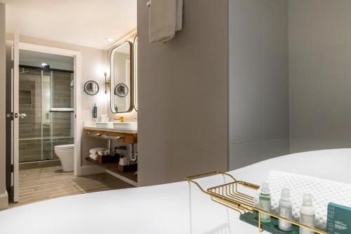 a white bathroom with a sink and a toilet at The Waterfront Beach Resort, A Hilton Hotel in Huntington Beach