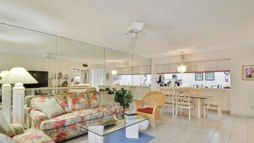 a living room with a couch and a kitchen at Atlantic Paradise by AvantStay Great Location w Balcony Outdoor Dining Shared Pool Hot Tub in Key West