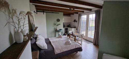 a bedroom with a bed and a large window at B&B Peelgoed in Kronenberg