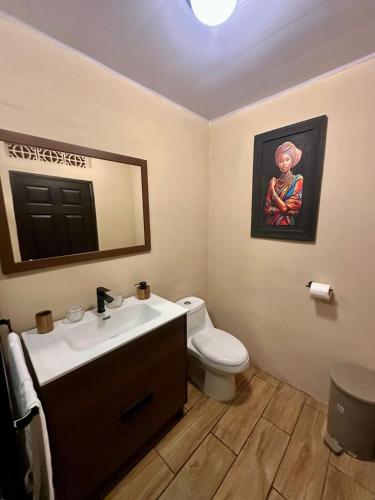 a bathroom with a sink and a toilet and a mirror at Hermosa Casa Familiar en Suchitoto in Aguacayo