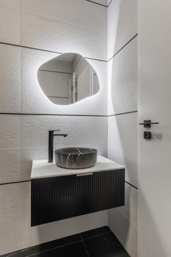 a bathroom with a sink and a mirror at The Signature by D'or Selection in Bucharest