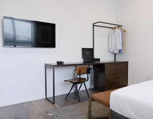 a bedroom with a desk with a mirror and a dresser at Sosuite at The Queen - Queen Village in Philadelphia