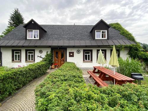 a house with a picnic table in front of it at Apartmány u Dostálů in Bedřichov