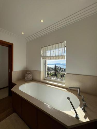 a large bath tub in a bathroom with a window at La Villa in Sainte-Maxime