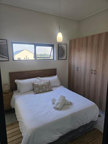 a bedroom with a large bed with white sheets at Sir Chase Place in Boksburg