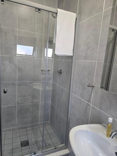 a shower with a glass door in a bathroom at Sir Chase Place in Boksburg