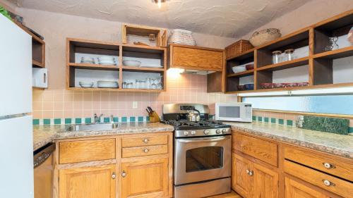 a kitchen with wooden cabinets and a stove top oven at Telluride Lodge 312 by AvantStay Close to Slopes Town in Telluride