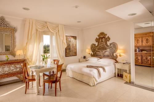 ein Schlafzimmer mit einem großen Bett, einem Tisch und einem Schreibtisch in der Unterkunft Arcom Palace in Pomezia