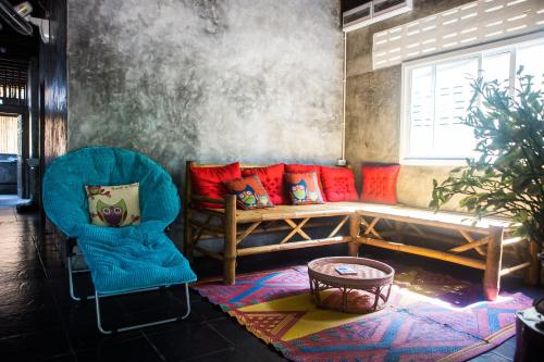 a living room with a couch and two chairs at Sweet Life Community Guesthouse in Ko Lanta