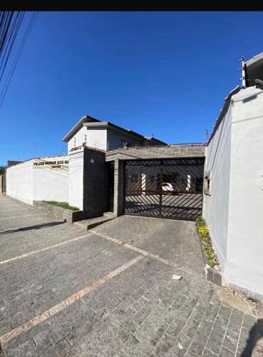 a building with a gate in a parking lot at Seu Refúgio no Guarujá in Guarujá