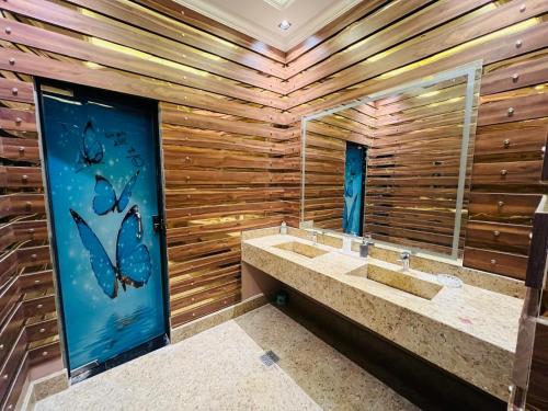 a bathroom with two sinks and a wooden wall at فيلا دريم in Sphinx International Airport