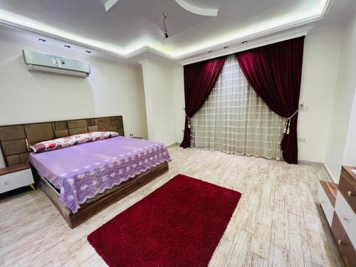 a bedroom with a bed and a red rug at فيلا دريم in Sphinx International Airport