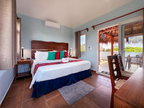 a bedroom with a large bed and a balcony at Casa Sonoma - Charming Condos Minutes from Beach & Reef in Puerto Morelos