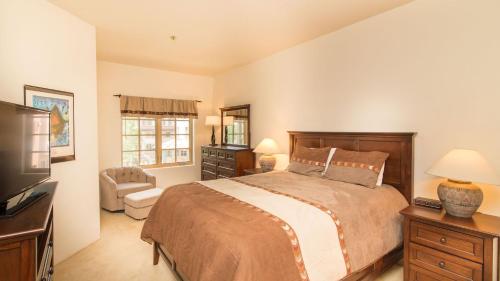 a bedroom with a large bed and a television at Westermere 311 - 2 by AvantStay Just Steps From Ski Area w Great Views in Telluride