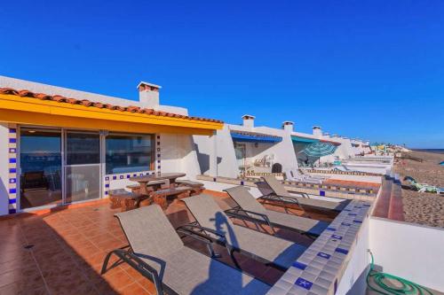 a group of chairs and tables on a patio at Beautiful Beachfront Condo Olas I 16 in Puerto Peñasco