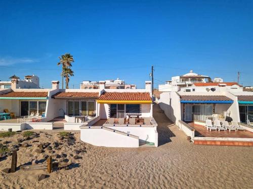 a house on a sandy beach with aconservancyconservancy at Beautiful Beachfront Condo Olas I 16 in Puerto Peñasco
