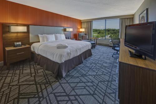 a hotel room with a bed and a flat screen tv at Hilton Knoxville Airport in Alcoa