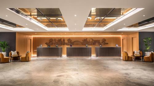 a lobby with two tables and chairs in a room at Hilton London Metropole in London