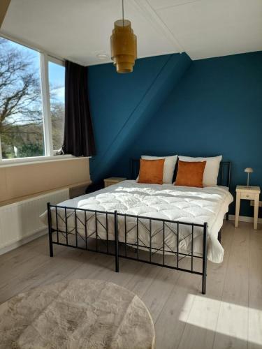 a bedroom with a bed with a blue wall at Het Gewei in Burgh Haamstede