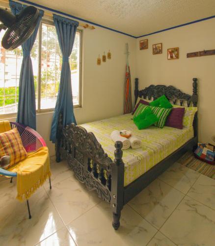 a bedroom with a bed with green pillows at Antigua Hostal in Bucaramanga