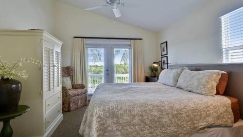 a bedroom with a bed and a chair and a window at Coral Villa by AvantStay Close 2 DT Key West Shared Pool Patio in Stock Island