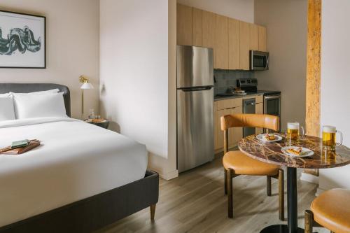 a hotel room with a bed and a table and a kitchen at LIVN West Loop Chicago Classic Queen Studio in Chicago