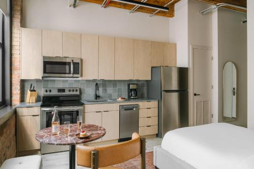 a small kitchen with a table and a bed at LIVN West Loop Chicago Classic Queen Studio in Chicago