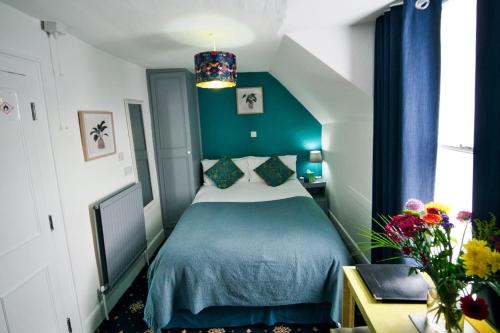 a bedroom with a bed with a blue bedspread at The Beaumont in Sittingbourne