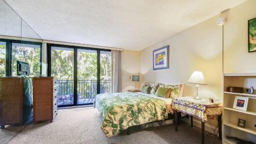 a bedroom with a bed and a balcony at Beachfront 2BDR Condo Pool Hot Tub w Ocean Views Papaya Place by AvantStay in Key West