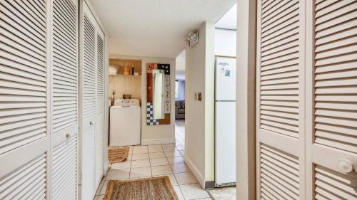 a kitchen with a refrigerator and a tile floor at Beachfront 2BDR Condo Pool Hot Tub w Ocean Views Papaya Place by AvantStay in Key West
