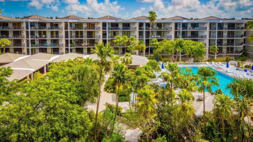 an aerial view of a resort with a pool and palm trees at Beachfront 2BDR Condo Pool Hot Tub w Ocean Views Papaya Place by AvantStay in Key West
