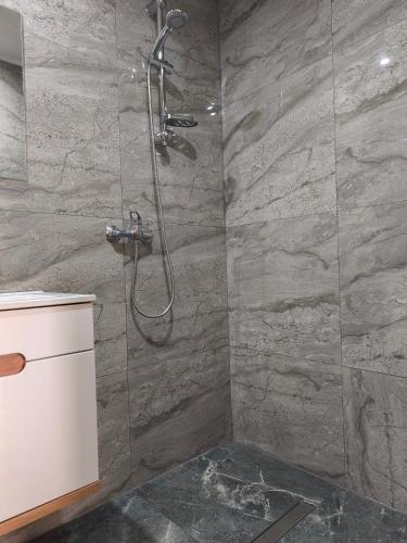 a shower in a bathroom with a stone wall at Za potokiem-Solina 66-77-44-4-61 in Solina
