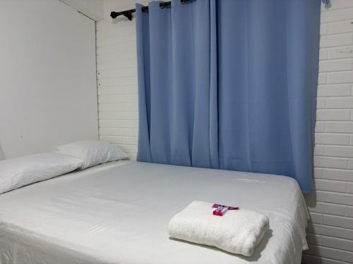 ein Bett mit einer weißen Decke und einem blauen Vorhang in der Unterkunft Full studio with parking in Bacalar