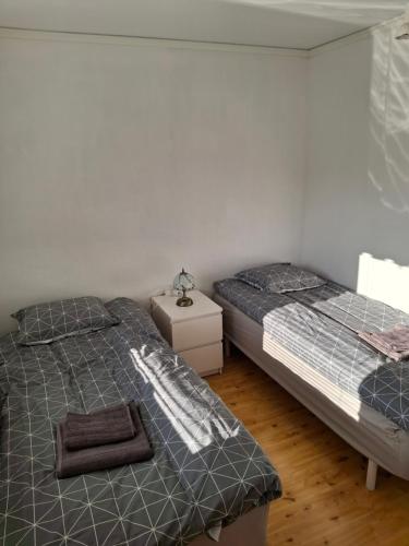 a bedroom with two beds and a night stand at bekväm villa in Fliseryd