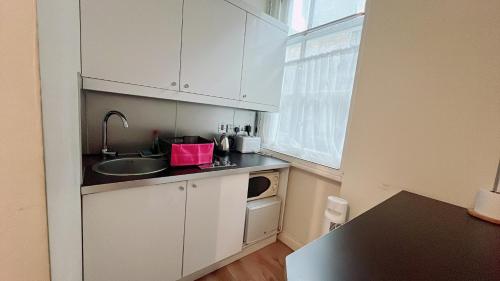 a small kitchen with a sink and a microwave at Soho China Town Rooms in London