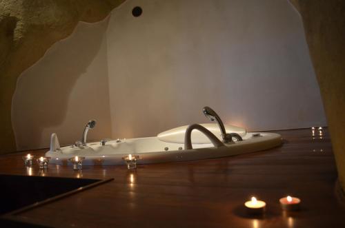 a bathroom with a bath tub with candles on the floor at Locus Amoenus in Matera