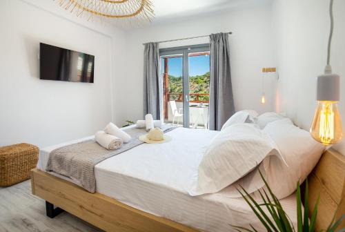 a bedroom with a bed and a tv and a window at East Coast in Alyki