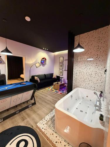 a living room with a tub and a couch at شقة فاخرة بجاكوزي وبلياردو دخول ذاتي in Hail