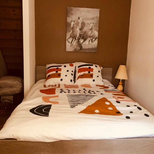a bedroom with a bed with a comforter with horses on it at Locéane in Le Pêchereau