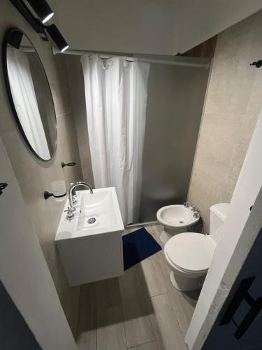 a bathroom with a sink and a toilet and a mirror at Mansilla playa in Mar del Plata