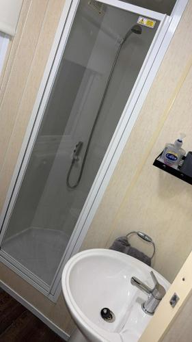 a bathroom with a shower and a white sink at The Cosy Coastal Caravan in Morecambe