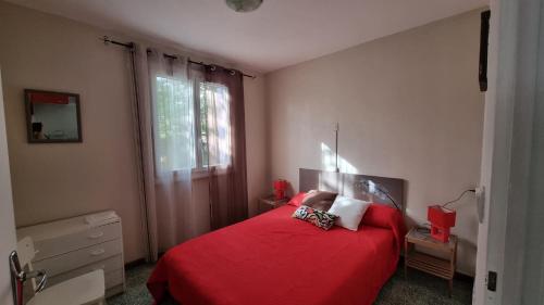 a bedroom with a red bed and a window at T2Leucate La Franqui Calme Mer Clim Parking P in Leucate