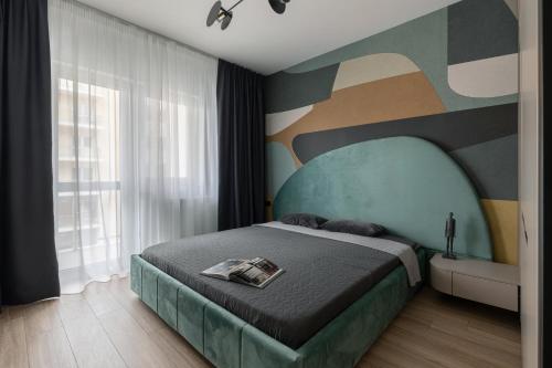 a bedroom with a bed with a painting on the wall at The Aristocrat by D'or Selection in Bucharest
